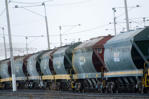 Heavy rail freight train carriages idling - Mining Photo Stock Library