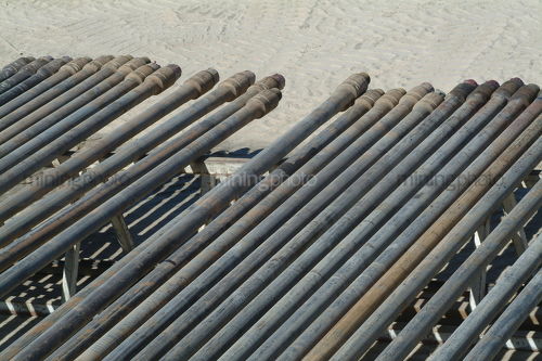 Drill rig casing pipe laid out ready to install - Mining Photo Stock Library