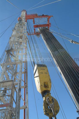 Looking up the derrick with pipe casing hanging on drill rig - Mining Photo Stock Library