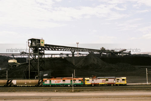 Coal train at wharf terminal with coal stockpiles in background. aerial shot - Mining Photo Stock Library