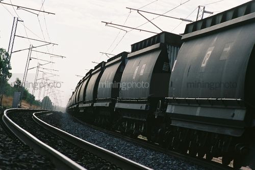 Great shot of loaded coal carriages thundering past. shot from track level - Mining Photo Stock Library