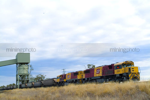 Coal train being loaded by hopper via conveyor - Mining Photo Stock Library