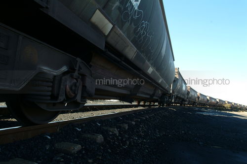 Heavy coal train carriages on track.  shot from ground level - Mining Photo Stock Library