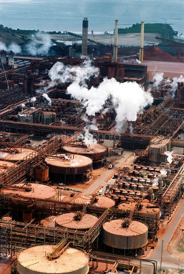 Aerial of bauxite refinery with port in background. - Mining Photo Stock Library