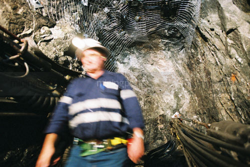 Underground mine worker walking towards machinery.  movement. - Mining Photo Stock Library