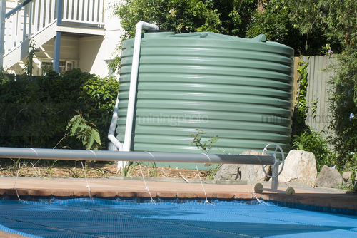 Domestic water tank adjacent to swimming pool in residential house. - Mining Photo Stock Library