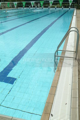 Edge of a swimming pool showing ladder - Mining Photo Stock Library