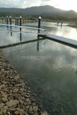 Pontoon and jetty's at a domestic residential subdivision with rock wall edge in foreground - Mining Photo Stock Library