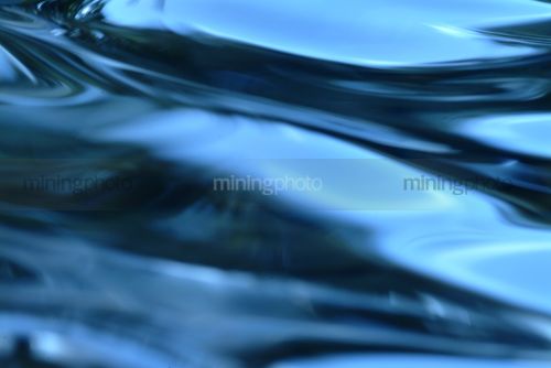 Closeup of blue water movement and pattern - Mining Photo Stock Library