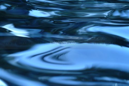 Closeup of blue water movement and pattern - Mining Photo Stock Library