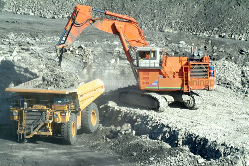 Digger loading a haul truck with overburden on opencut mine floor. - Mining Photo Stock Library