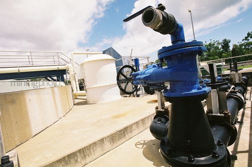 Water pump and concrete holding tanks at water treatment plant. - Mining Photo Stock Library