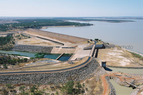 Large outback dam with road over dam wall. well stocked with water. - Mining Photo Stock Library