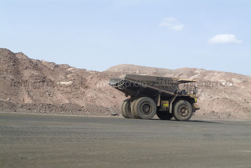 Haul truck moving along haul road in open cut mine site.  logs of space in photo for text. - Mining Photo Stock Library