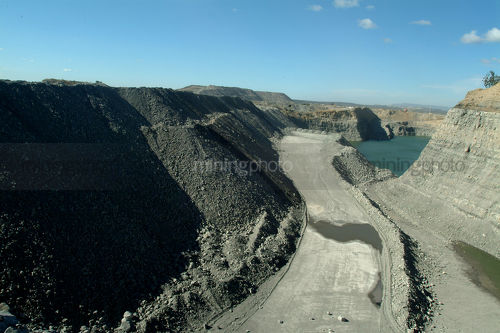 Looking down coal high walls to haul road and coal tailings dam - Mining Photo Stock Library