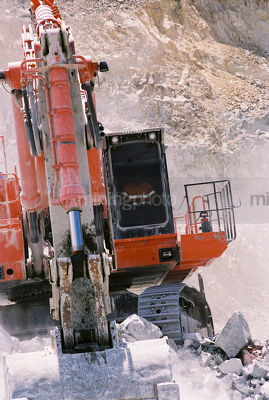 Excavator shot straight on loading  in open cut mine site environment. - Mining Photo Stock Library