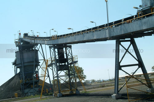 High covered enclosed conveyor leading up to stockpile hopper. - Mining Photo Stock Library