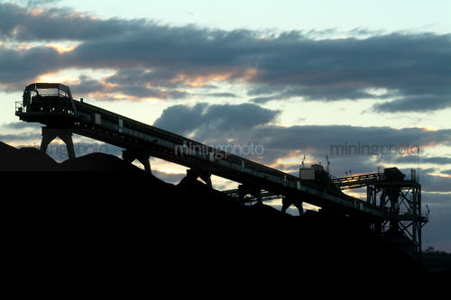 Conveyor stockpiling coal at dusk - Mining Photo Stock Library