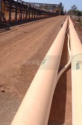Water pipes next to road on processing pant mine site - Mining Photo Stock Library