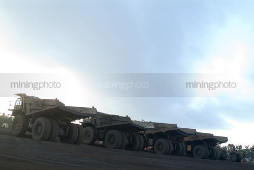 Lots of haul trucks at the go line of open cut mine - Mining Photo Stock Library