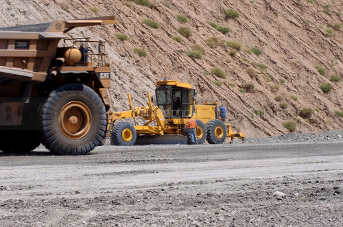Haul truck passing grader on open cut mine site - Mining Photo Stock Library