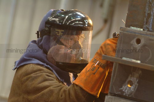 Worker in full PPE welding steel - Mining Photo Stock Library