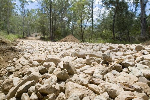Rocks form road base on forestry road.  shot at ground level to accentuate the diameter of the stones. - Mining Photo Stock Library