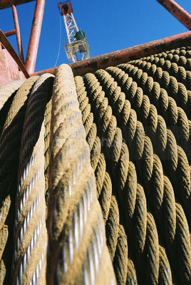 Rope cable stretched tight n cable drum on mine site.  shot close up. - Mining Photo Stock Library