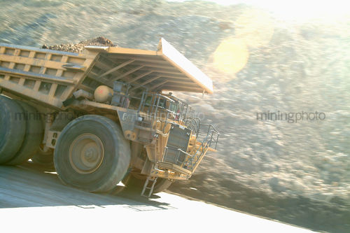 Loaded mine truck moving along haul road - Mining Photo Stock Library