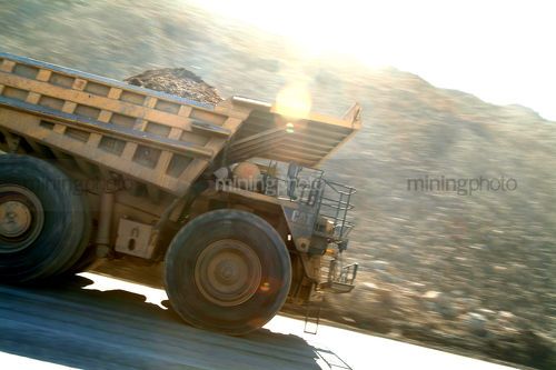 Loaded mine truck moving along haul road - Mining Photo Stock Library