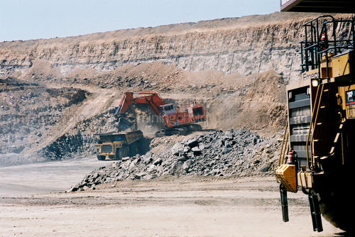 Excavator and haul truck removing overburden on the pit floor of open cut coal mine. - Mining Photo Stock Library