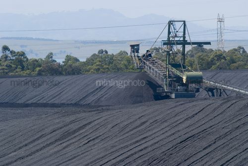 Close up of coal stacker stockpiling. - Mining Photo Stock Library