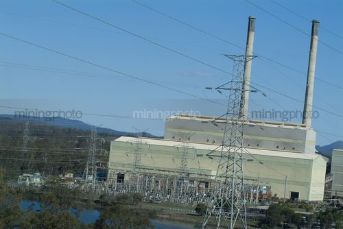 Close up of power station with cooling towers and power cables and electricity towers. - Mining Photo Stock Library