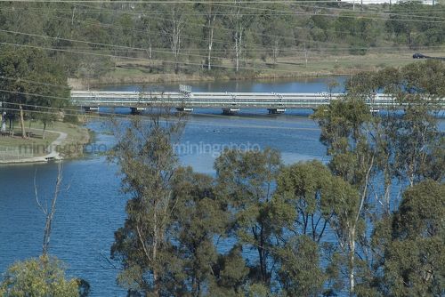 Water pipes on pipe bridge over lake - Mining Photo Stock Library