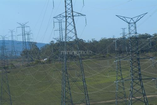 Electricity towers overland carrying power lines to city. - Mining Photo Stock Library