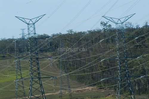 Electricity towers overland carrying power lines to city. - Mining Photo Stock Library
