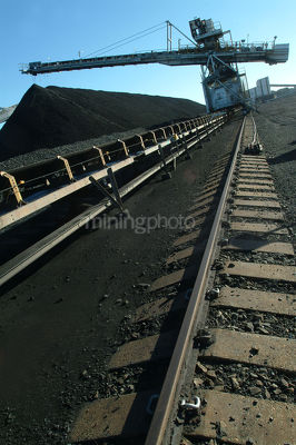 Coal loader on tracks stockpiling vertical image - Mining Photo Stock Library