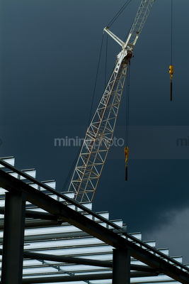 Crane on steel construction site shot with storm in background. close up , good line and form. - Mining Photo Stock Library