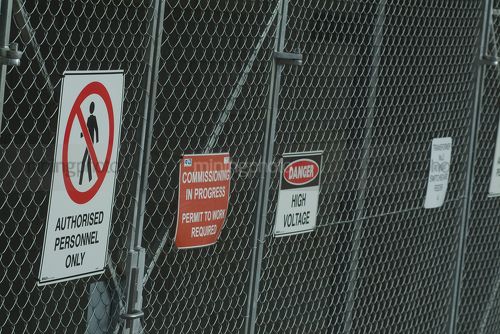 Wire fence with safety signs. permit to work - Mining Photo Stock Library
