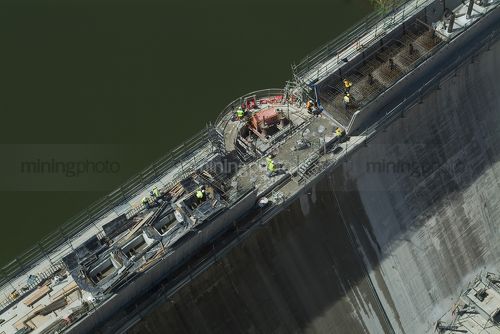 Steel formwork construction at the top of a dam wall with workers.  aerial shot  - Mining Photo Stock Library