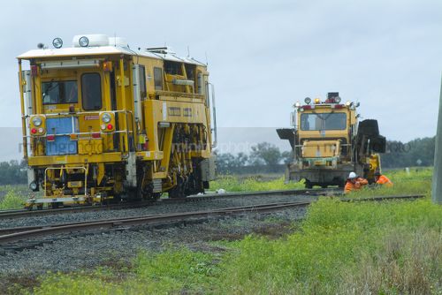 Rail track repair machinery and workers in rural setting. - Mining Photo Stock Library