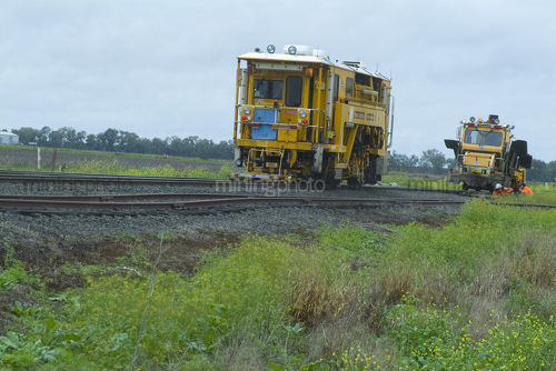 Rail track repair machinery and workers in rural setting. - Mining Photo Stock Library