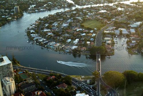 Boat on canal residential waterway in late afternoon.  aerial shot over gold coast. - Mining Photo Stock Library