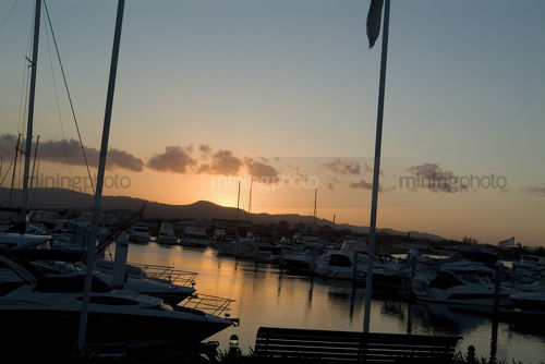 Sunset over boat harbour at residential waterfront living subdivision. - Mining Photo Stock Library