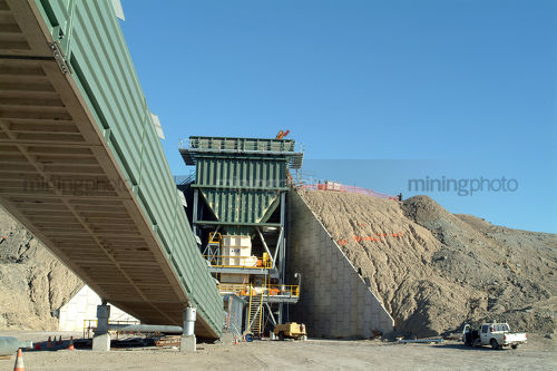 Covered coal conveyor being built with hopper and rom in background - Mining Photo Stock Library