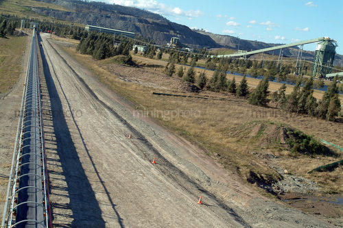 Covered coal conveyor leading to wash plant in background. - Mining Photo Stock Library