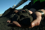 Mining Photo Stock Library - closeup of hands holding pieces of coal with stockpile and reclaimer out of focus in background ( Weight: 3  New Image: NO)