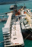 Mining Photo Stock Library - ship being loaded with bauxite by automatic conveyor. multi level wharf facility. some workers in PPE present.  aerial shot above wharf. ( Weight: 1  New Image: NO)