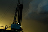 Mining Photo Stock Library - silhouetted worker walking down stairs of drill rig during afternoon thunderstorm  ( Weight: 1  New Image: NO)