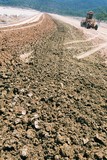 Mining Photo Stock Library - closeup of dirt on road with grader out of focus in background. ( Weight: 2  New Image: NO)
